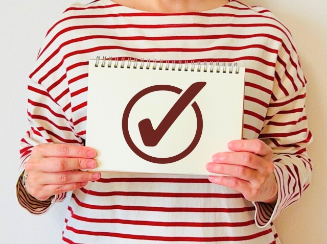 チェックマークを持つボーダ服の女性