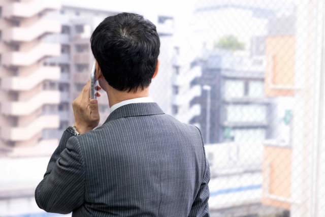 電話するビジネスマンの後ろ姿
