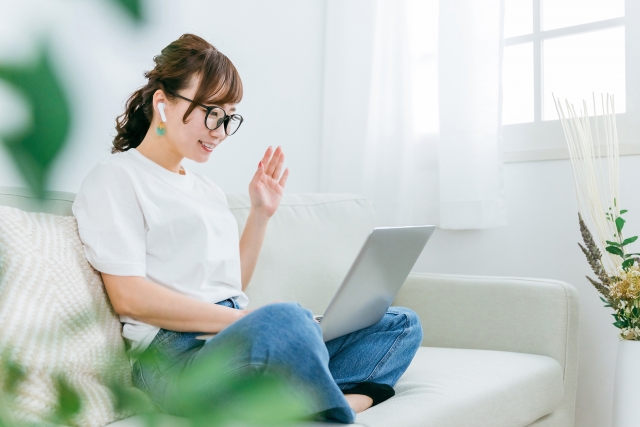 ソファでオンライン英会話レッスンを受ける主婦